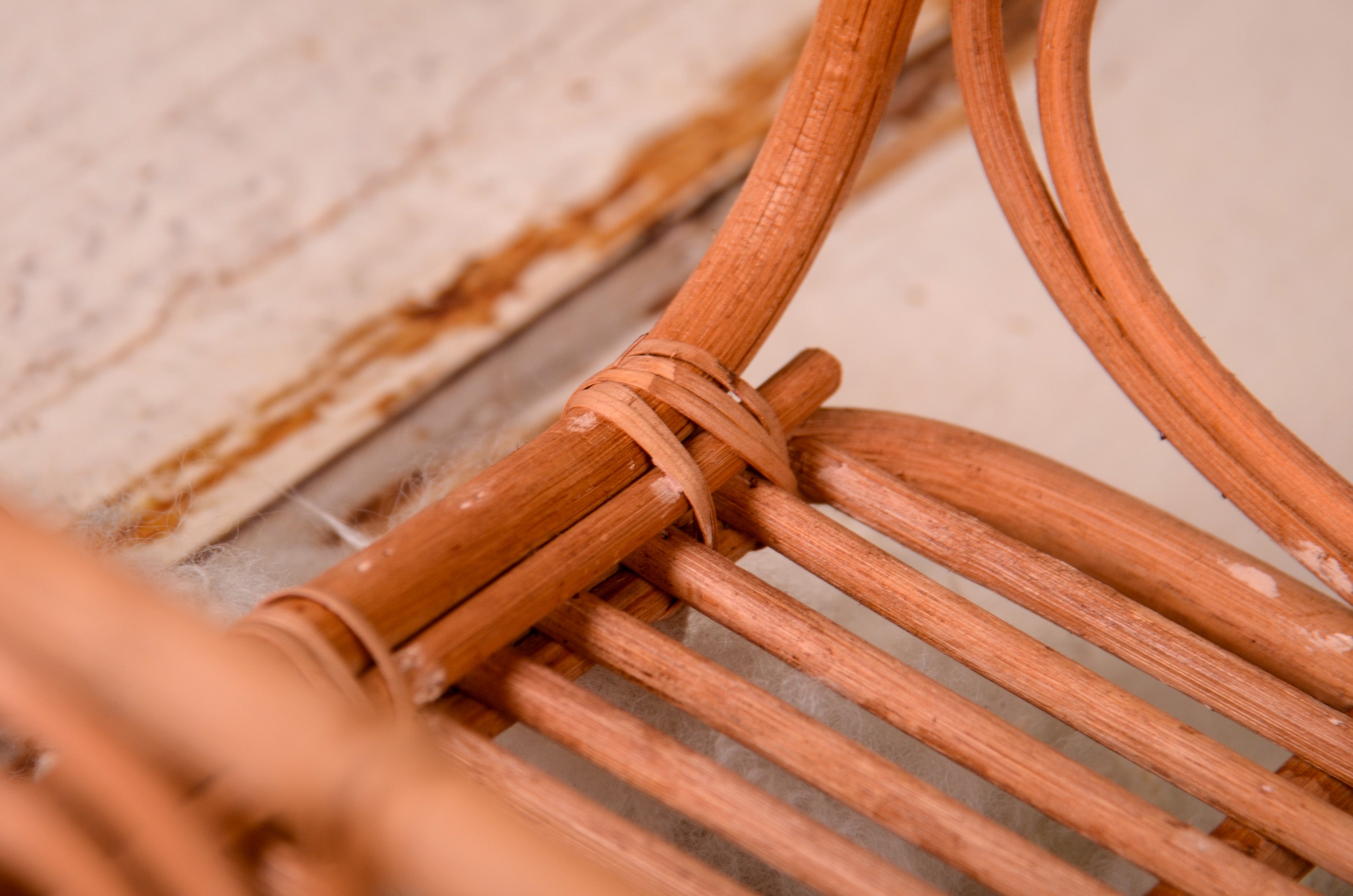 Rattan love nest newborn photography prop on a soft, fluffy rug.