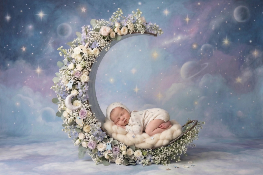 newborn photography prop crescent moon base with florals, cradling a sleeping baby in a dreamy galaxy set