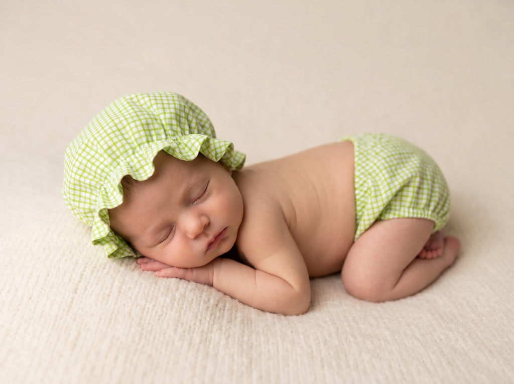 Newborn baby wearing a green checkered shower hat and diaper for newborn baby photoshoot