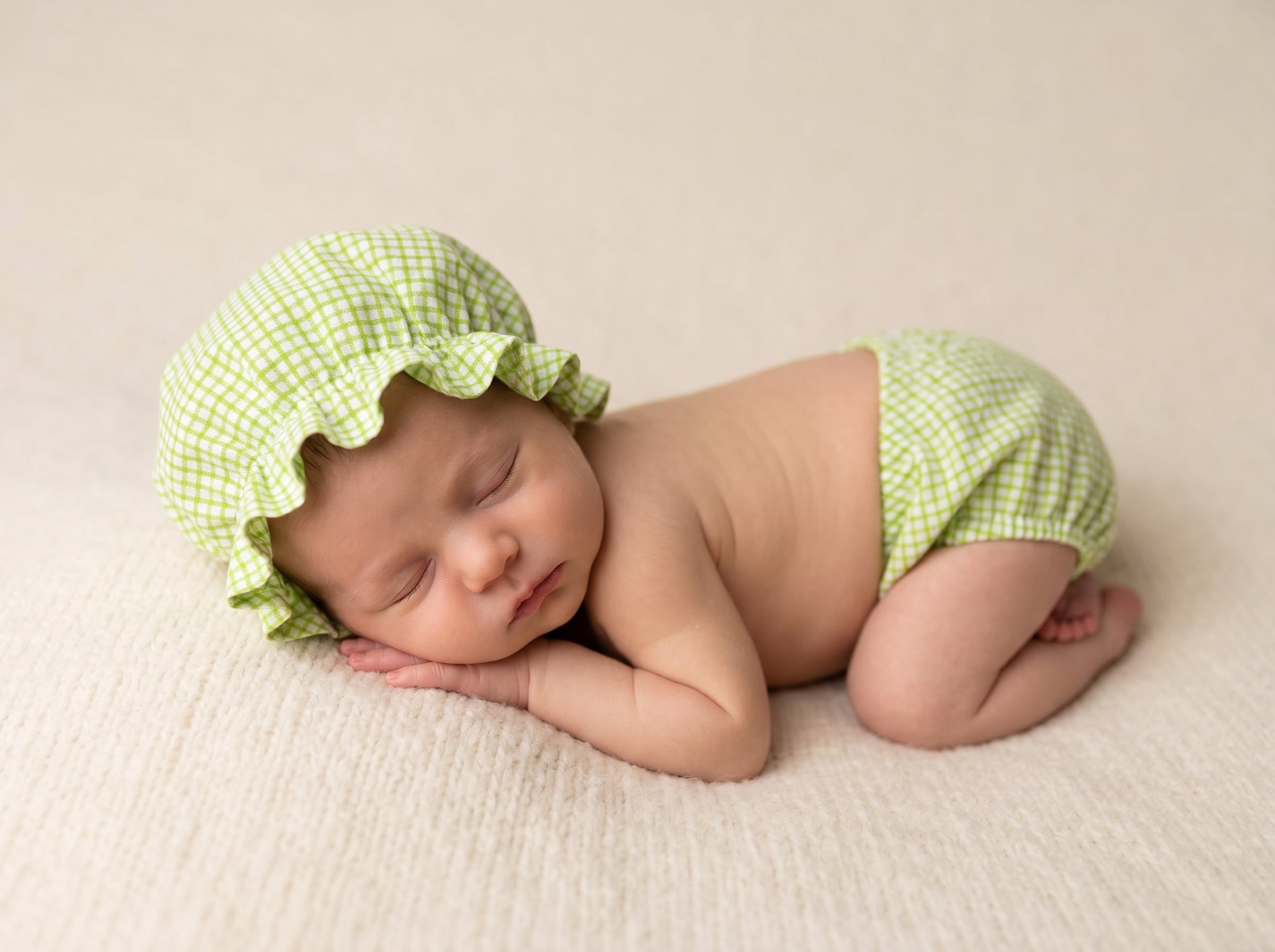 Newborn baby wearing a green checkered shower hat and diaper for newborn baby photoshoot
