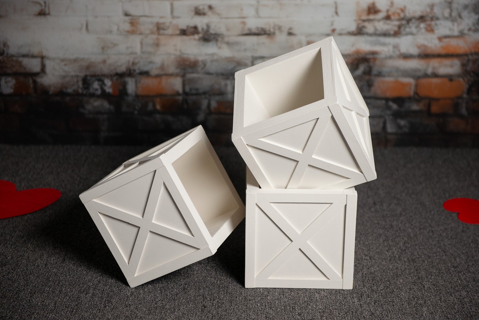 White wooden X-paneled boxes stacked on a textured floor, perfect as a newborn photography prop for rustic or farmhouse-themed sessions.