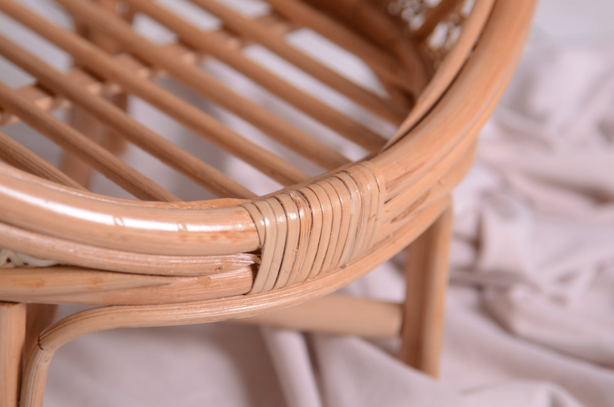 Zoomed-in view of the rattan nest cocoon newborn photography prop's base, focusing on the handwoven rattan binding securing the frame.