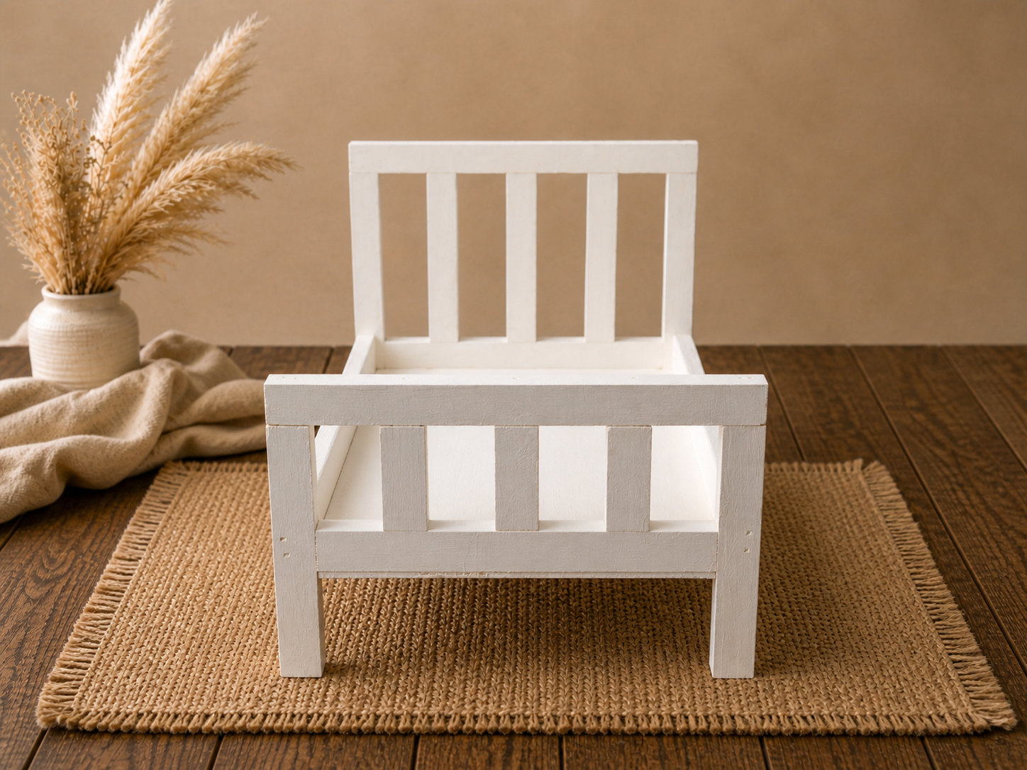 White wooden bed with straight headboard on a wooden floor setup for baby photography