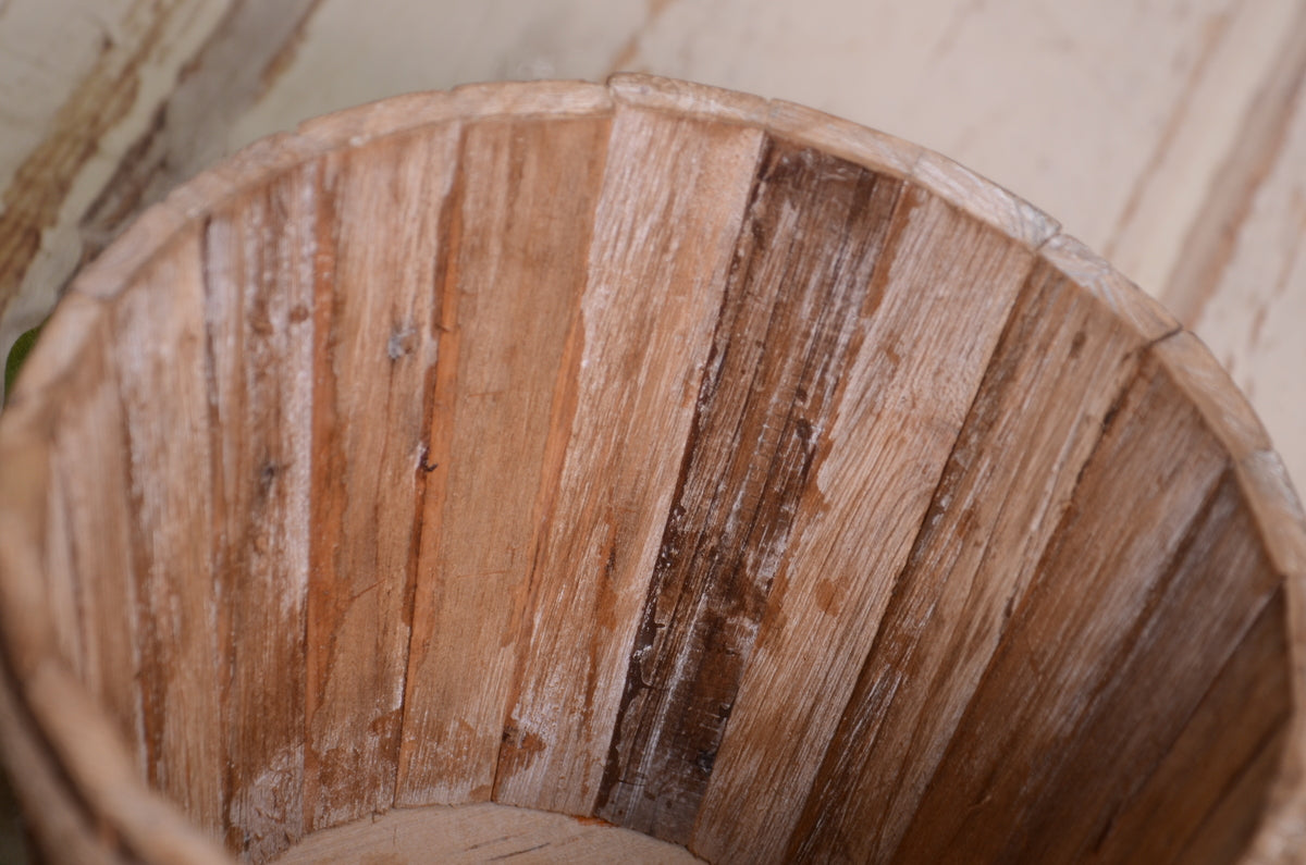 Rustic wood bucket with weathered texture and a rope-trimmed edge, perfect for newborn photography.