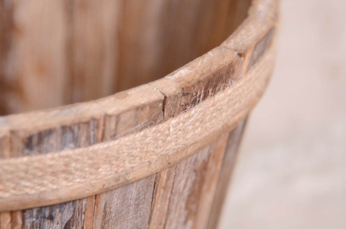 Vintage-inspired wooden bucket with a rope accent, a classic choice for newborn photography props. Closeup view