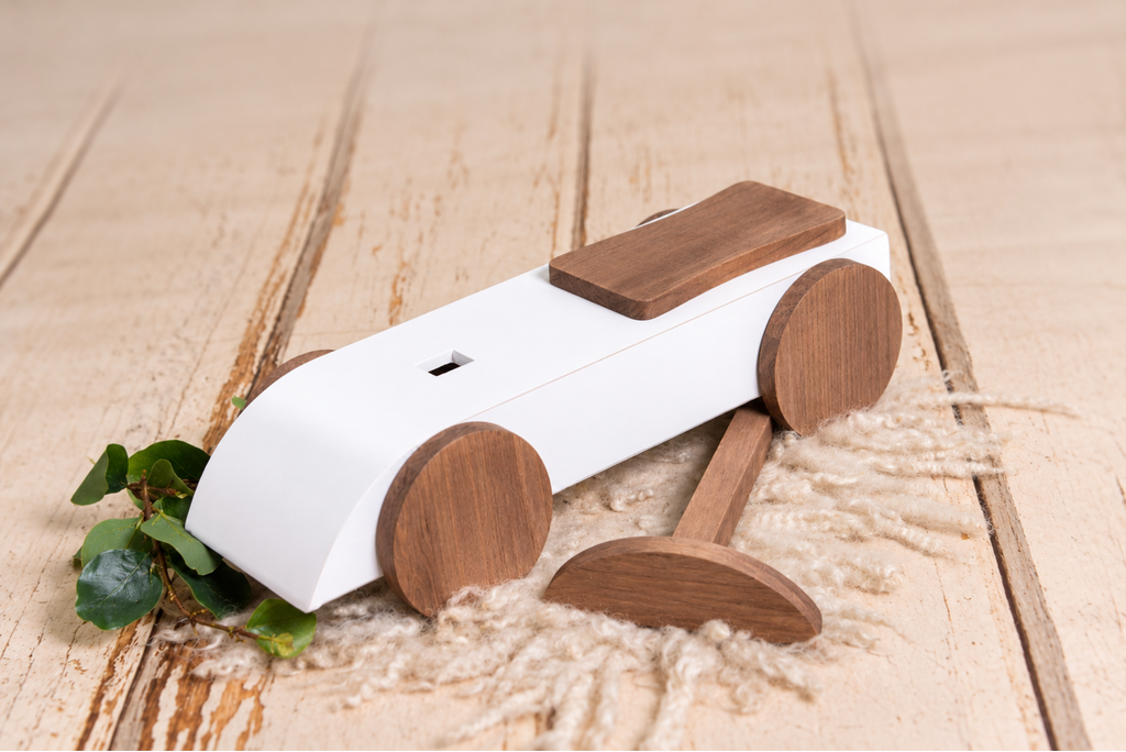 Side angle of the Rustic Ride-On - White, showcasing its wooden wheels and distressed white finish, a charming newborn photography prop.