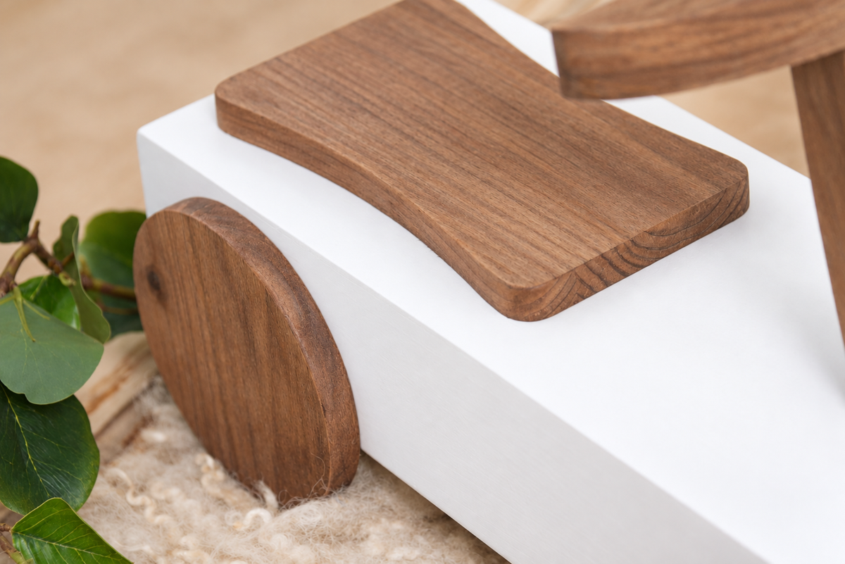 Close-up of the wooden seat and wheel of the Rustic Ride-On - White, highlighting its handcrafted details, perfect for vintage newborn photography themes.