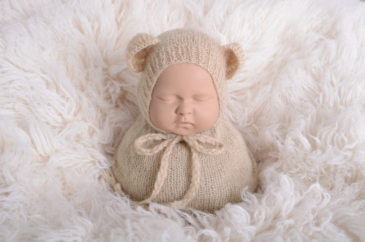 Newborn photography prop featuring a beige mohair bear bonnet and sack on a plush white background, designed for a serene and soft aesthetic.