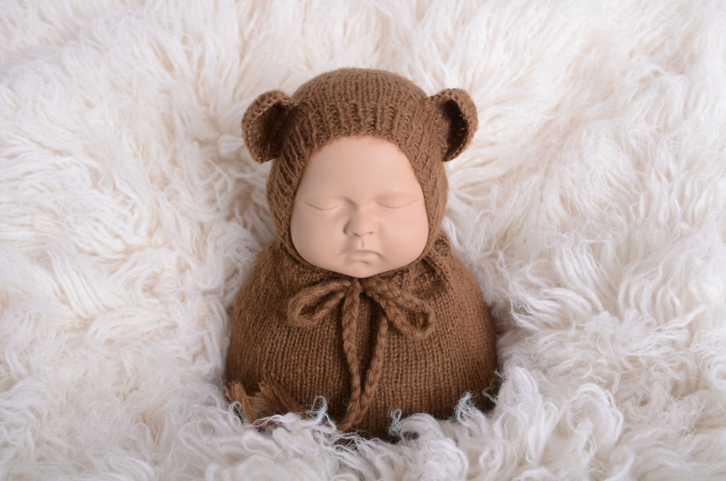 Newborn photography prop featuring a beige mohair bear bonnet and sack on a plush white background, designed for a serene and soft aesthetic.