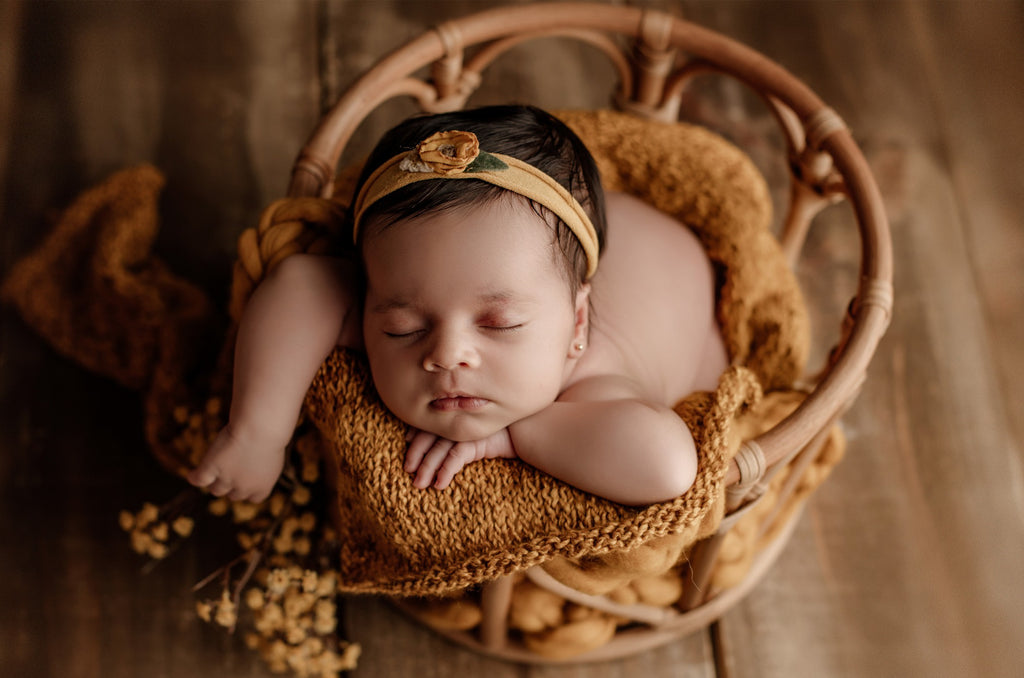 Cozy and charming! A smiling baby sits in a LovePod rattan basket with soft yellow textures, a dreamy newborn photography prop.
