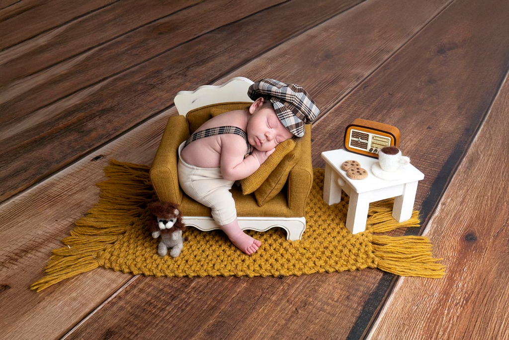Newborn photography prop featuring a mini mustard sofa, vintage outfit, and cozy rustic setup with end table.
