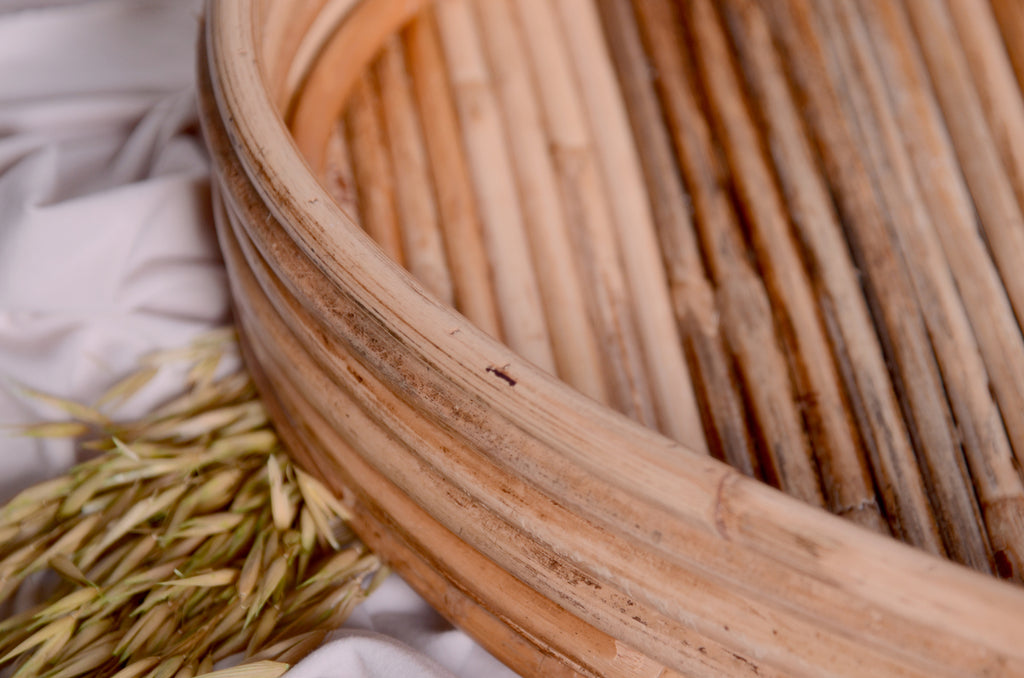 Angled close-up of the Rattan Heart Bowl, featuring the smooth rattan finish and rustic tones, enhancing its organic charm as a newborn photography prop.