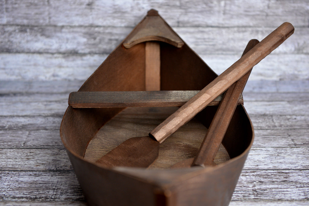 Front view of a wooden boat newborn photography prop with crossed oars inside