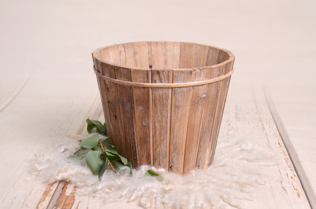 Rustic wooden bucket with a weathered finish, featuring vertical slats and a natural, vintage charm.