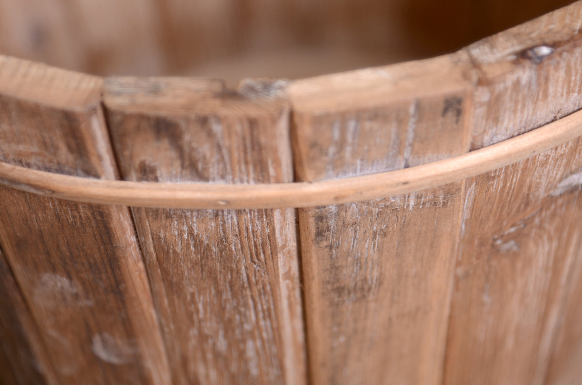 Vintage-style bucket made of rustic wood, featuring soft tones and a handcrafted slatted design.