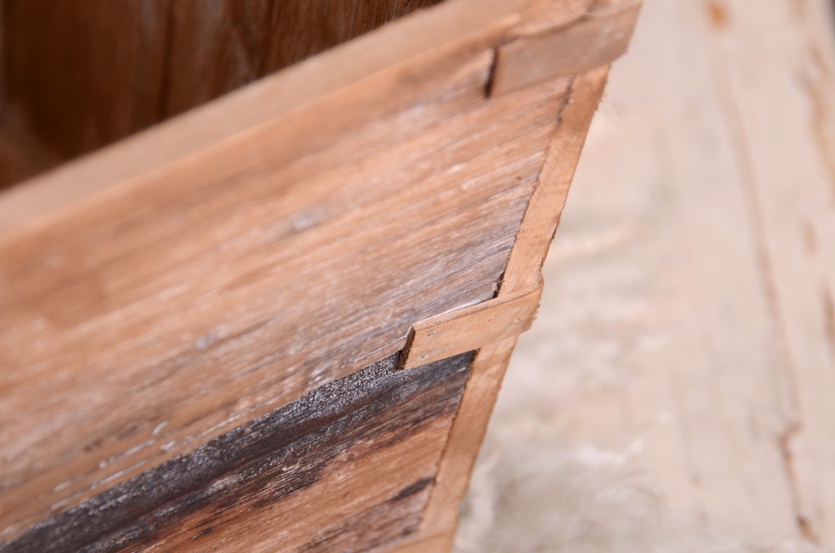 Rustic wooden crate with a natural wood finish and heart-shaped accents, styled with wool texture and leaves as a newborn photography prop.