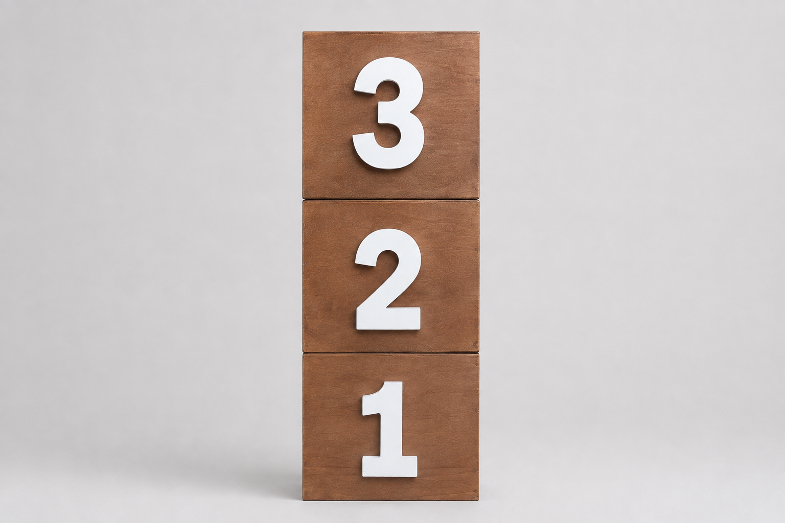 Three stacked wooden blocks for milestone photography displaying the numbers 3, 2, and 1 in white