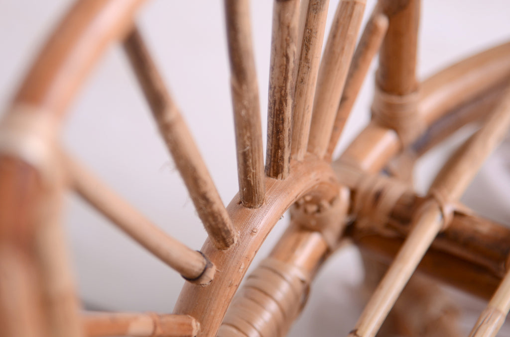 A macro view of the Sun-Kissed Rattan Cradle’s woven rattan knots and curves, showcasing its artisanal details—ideal for newborn photography setups.