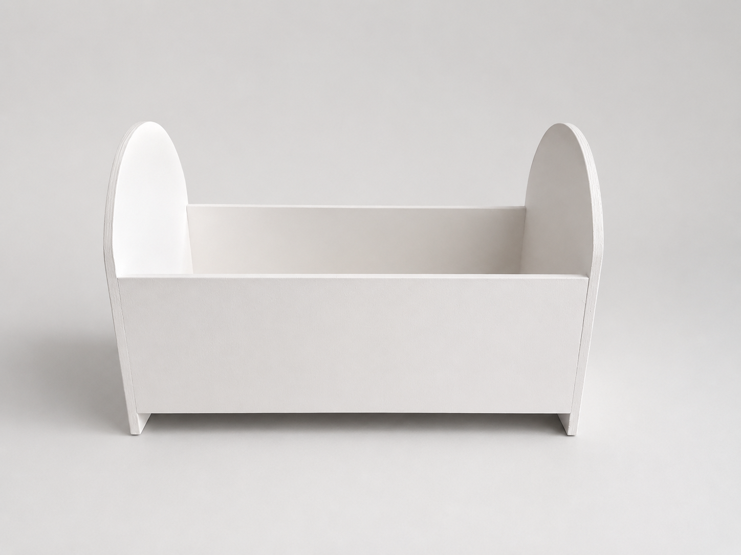 White newborn crib prop for photography on a light gray background