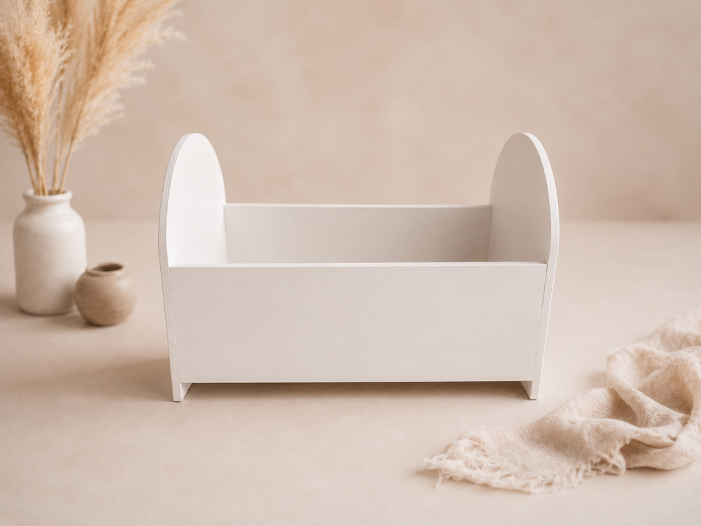 White doll crib on a beige surface with decorative elements
