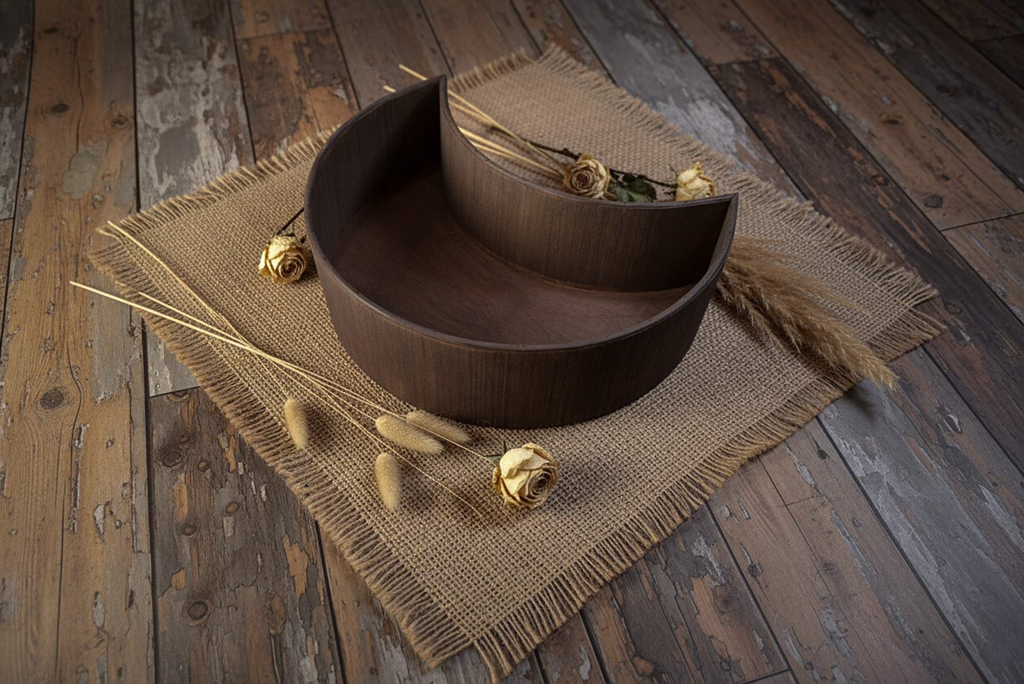 Mocha wooden moon bowl newborn photography prop on burlap mat with golden roses and pampas grass.