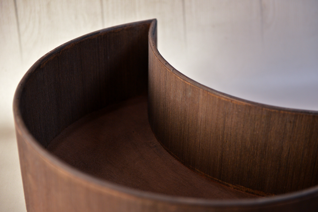 Close-up detail of mocha wooden moon bowl newborn photography prop showing smooth curved edges.