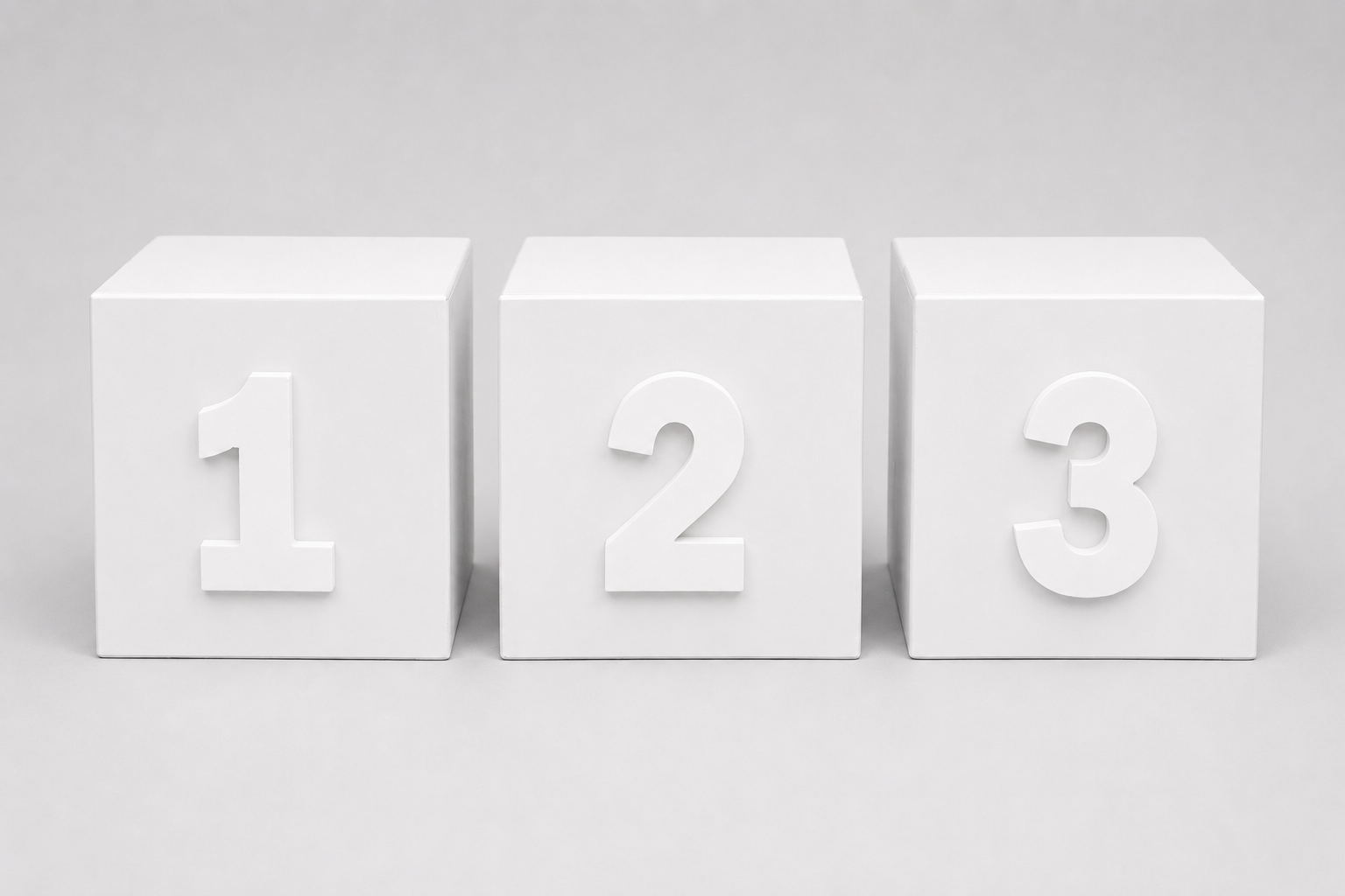 Three white cube blocks for cake smash photography arranged side by side, each displaying a raised number from 1 to 3