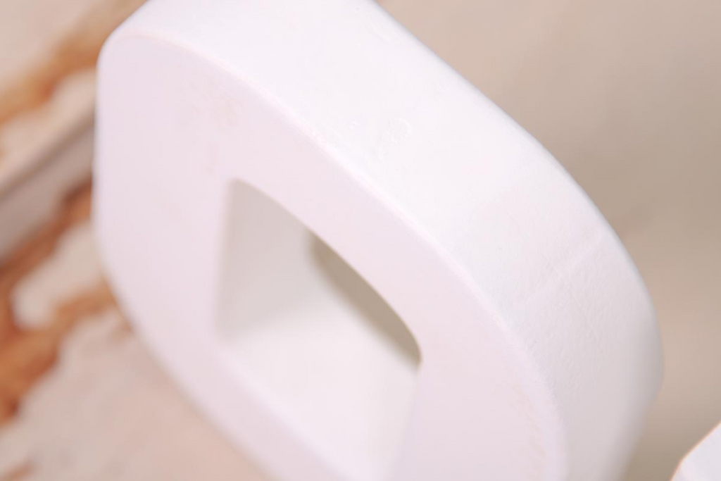 White wooden letters spelling out 'ONE' on a rustic wooden background, ideal for cake smashes or milestone photography.