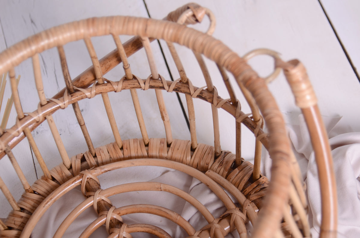  A detailed shot of the rattan basket’s curves and textures, paired with soft fabric for a cozy, organic newborn session.