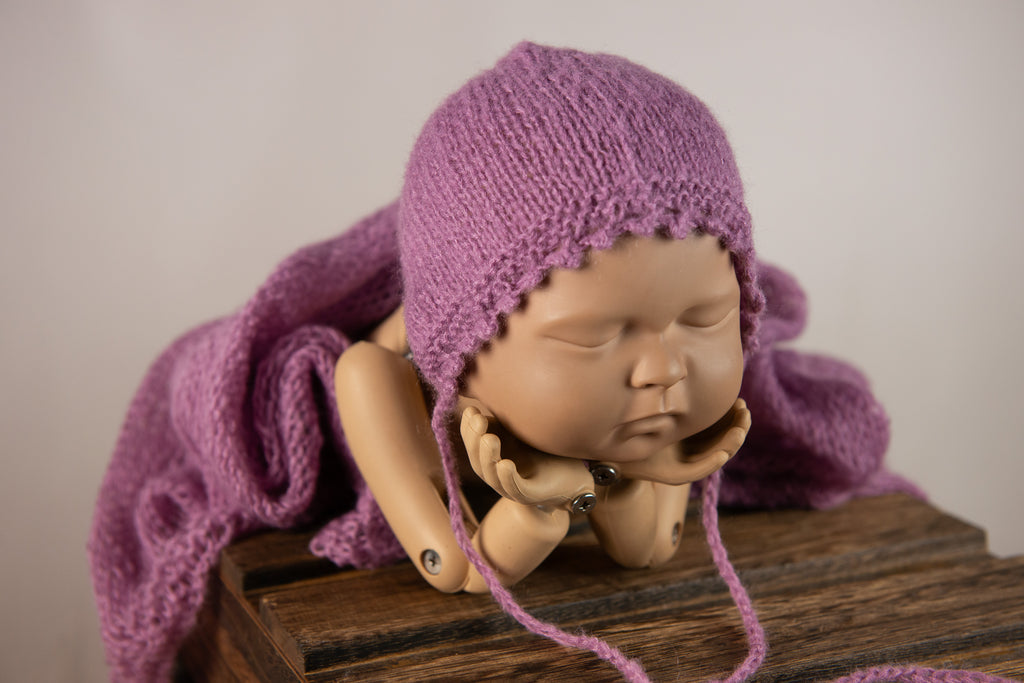 Gray knit hat on sleeping doll showcases newborn photography prop versatility.