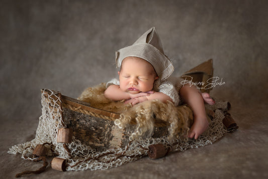 Lovely rustic handmade boat with oars made of wood. Ideal to cradle newborns during your photography shoots.