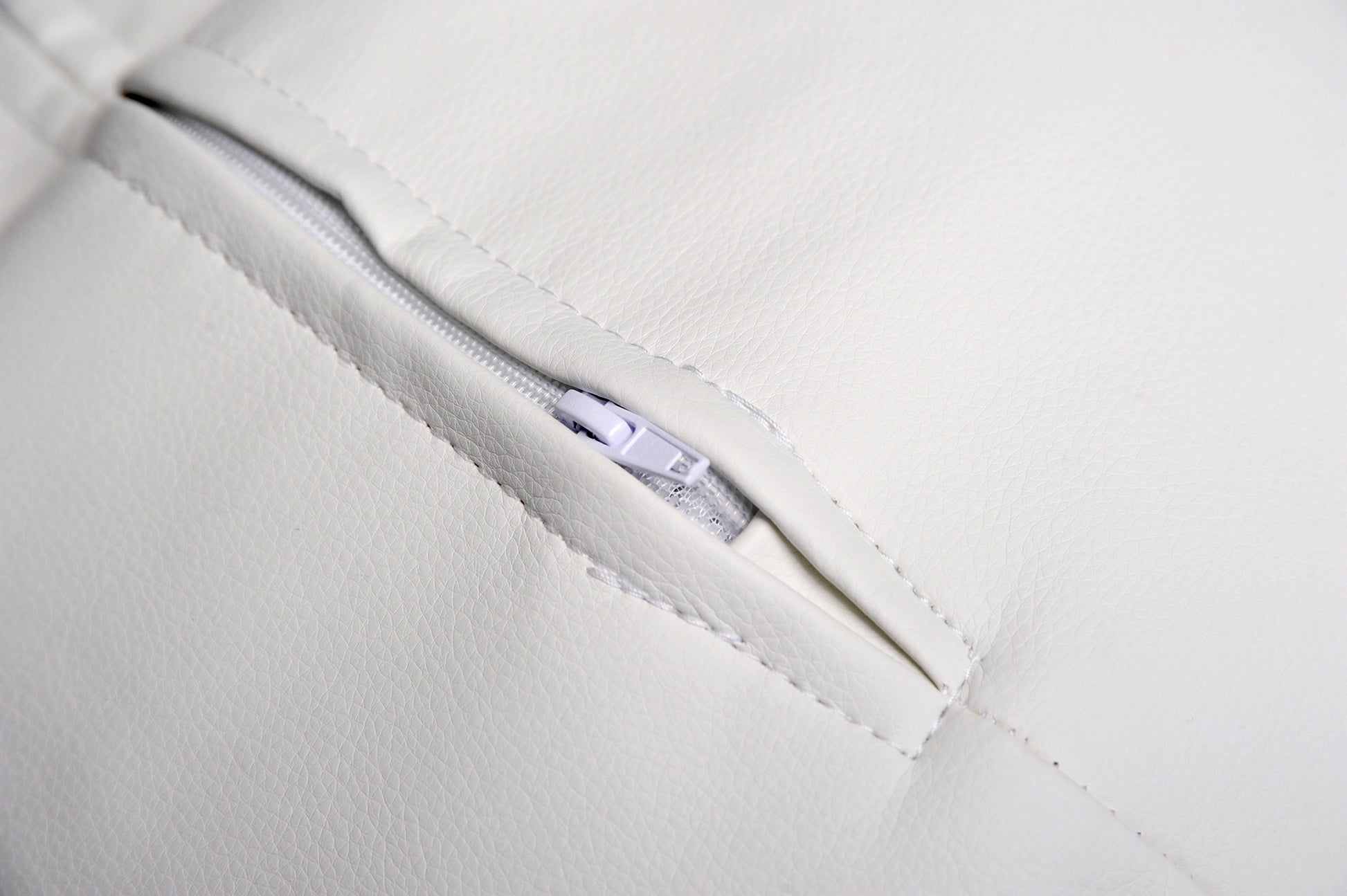 Detailed view of the quality seam with zipper of a white newborn photography prop pillow.