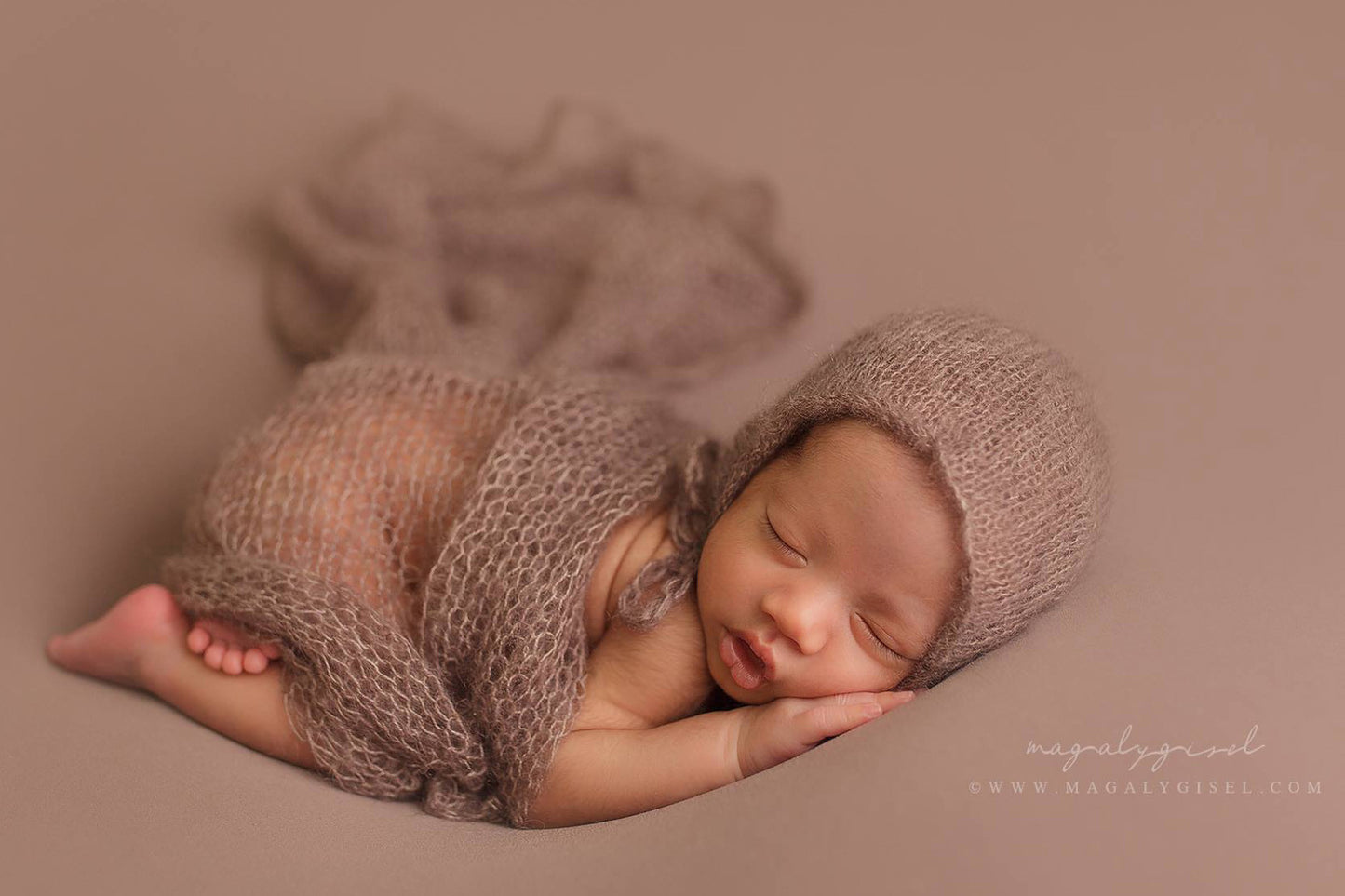 Sleeping newborn on a brown textured blanket, posed on a Posing Bean Bag